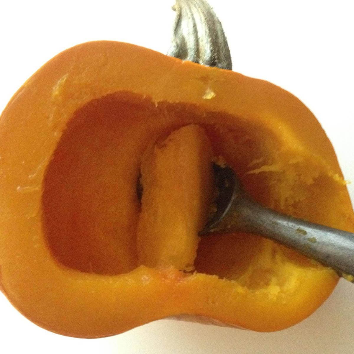 Removing pumpkin from the skin using an ice-cream scoop.