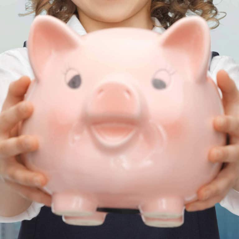 Girl holding a piggy bank with both hands.