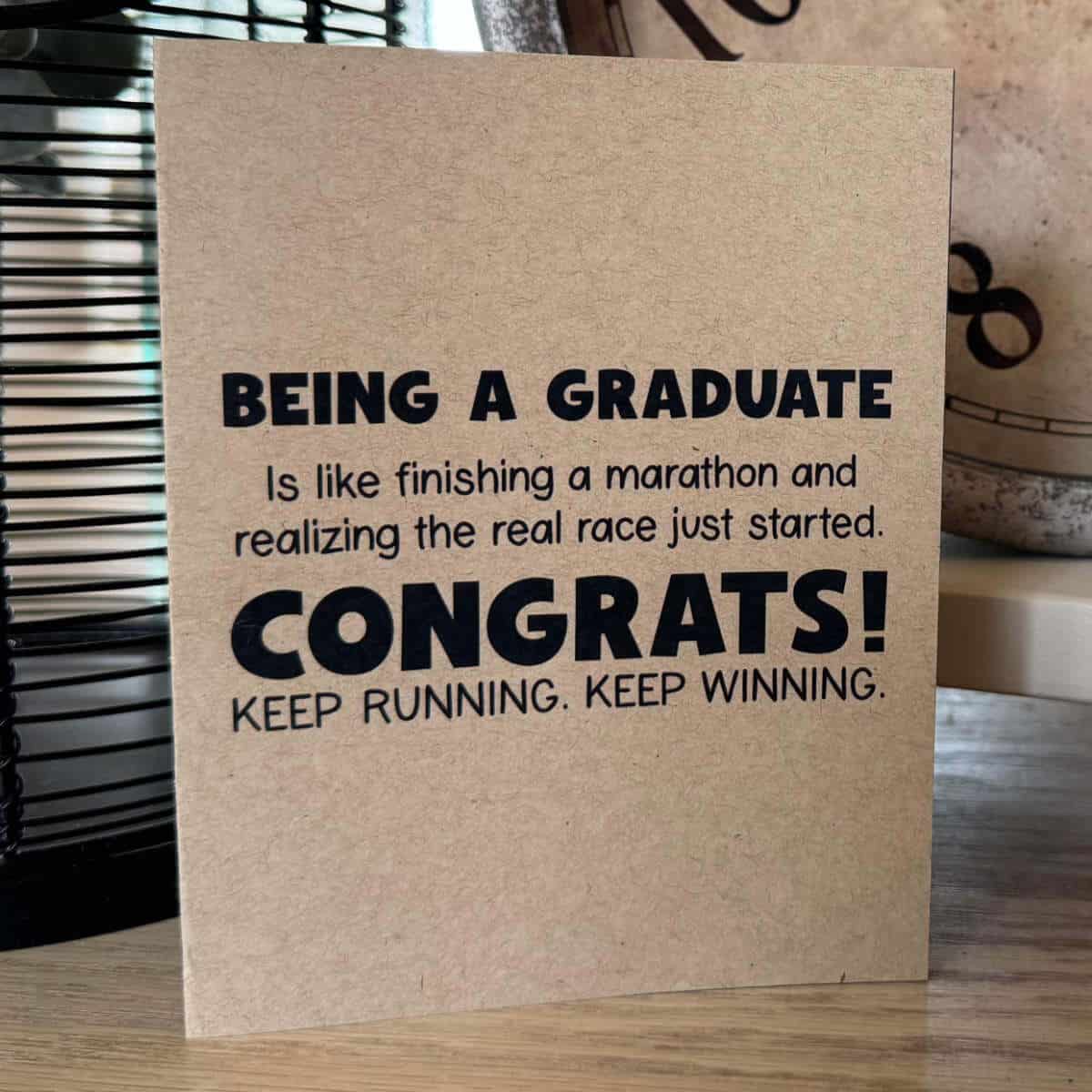 Printable graduation card that says: Being a graduate is like finishing a marathon and realizing the real race just started. Congrats! Keep running. Keep winning.