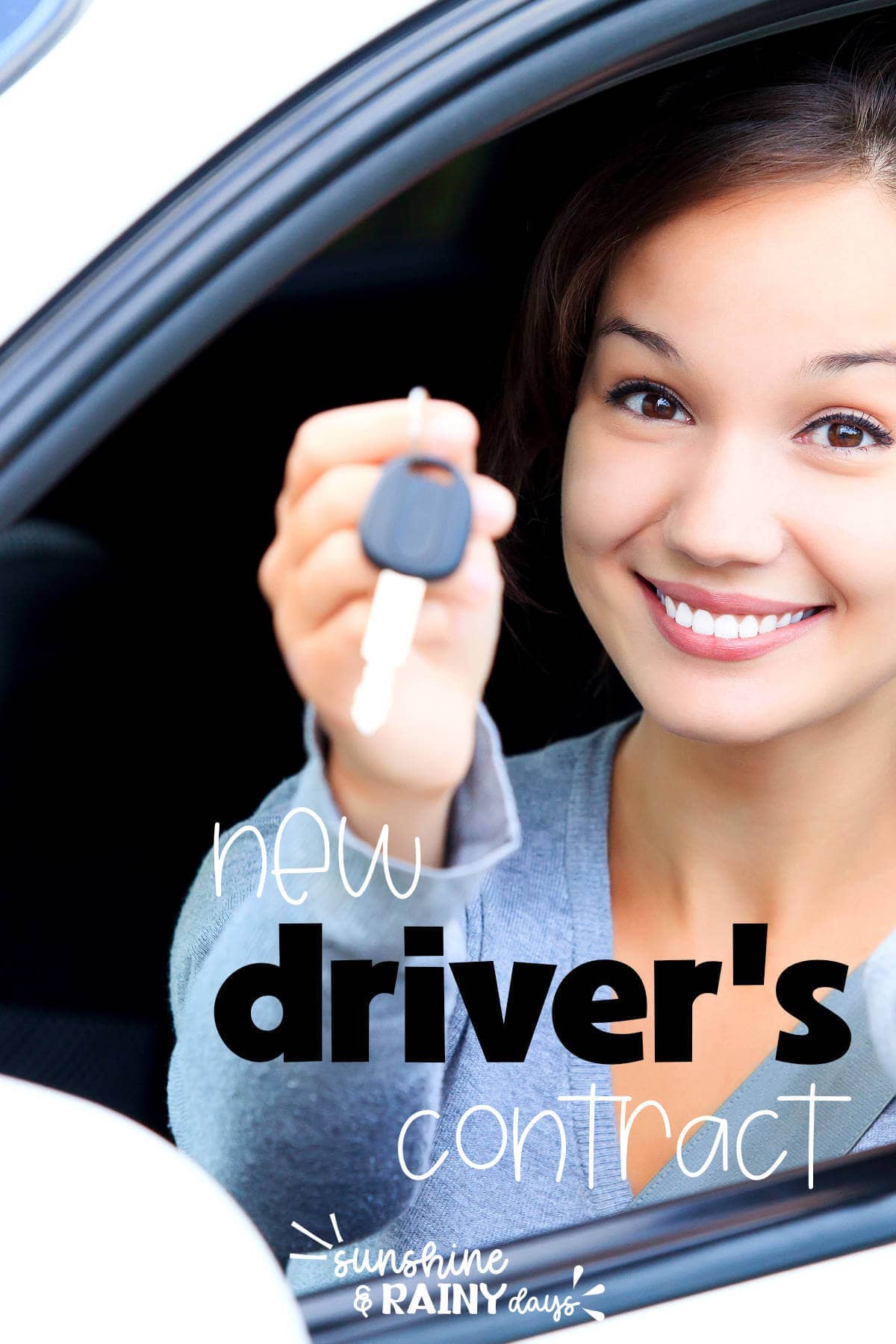 New driver holding car keys and sitting in the driver's seat.