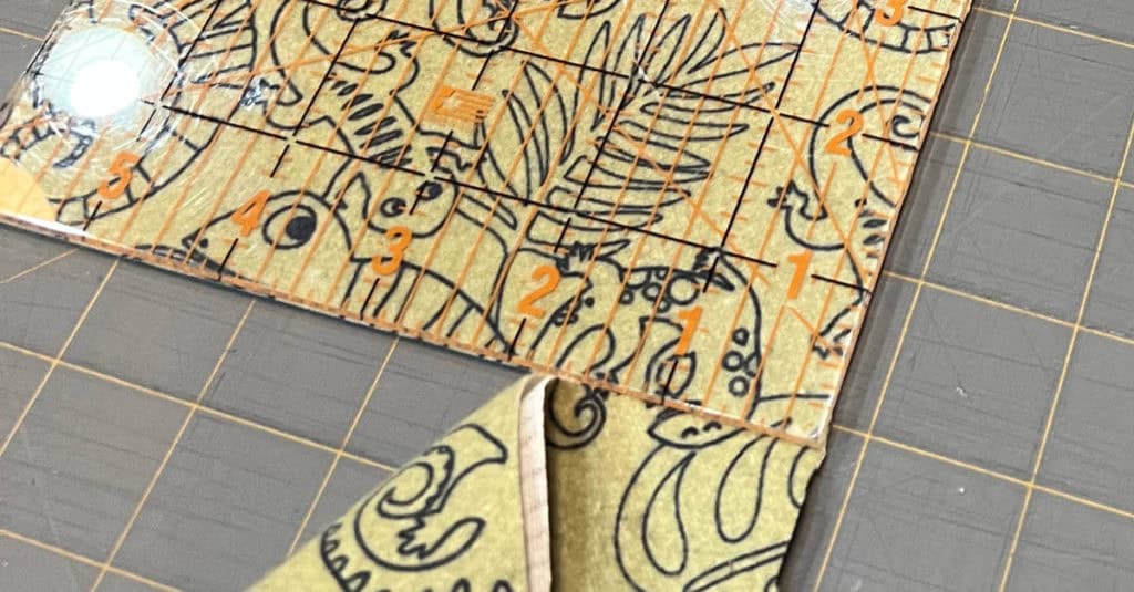 Cutting fabric using an acrylic ruler.