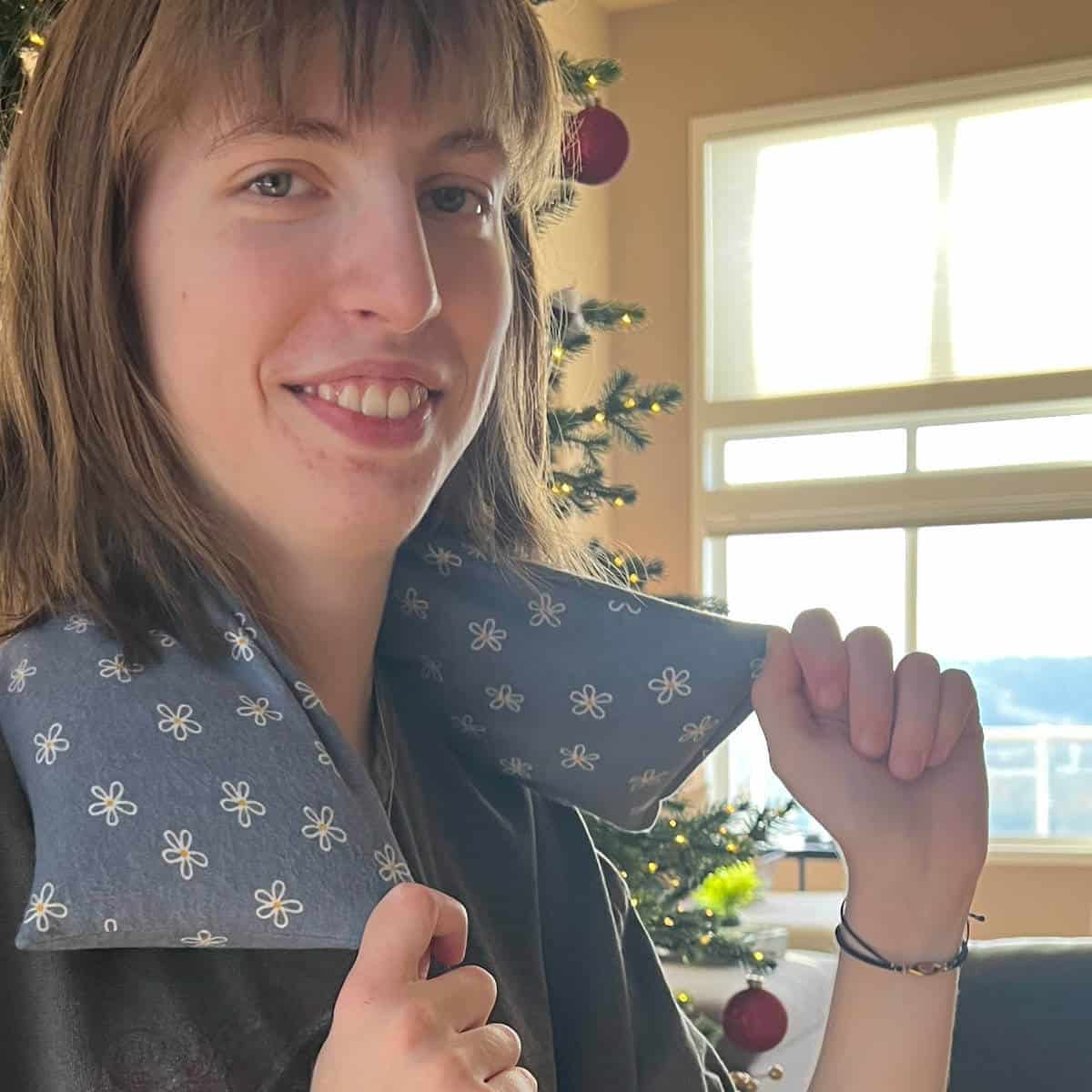 Young adult with a flax seed heating bag around her neck.