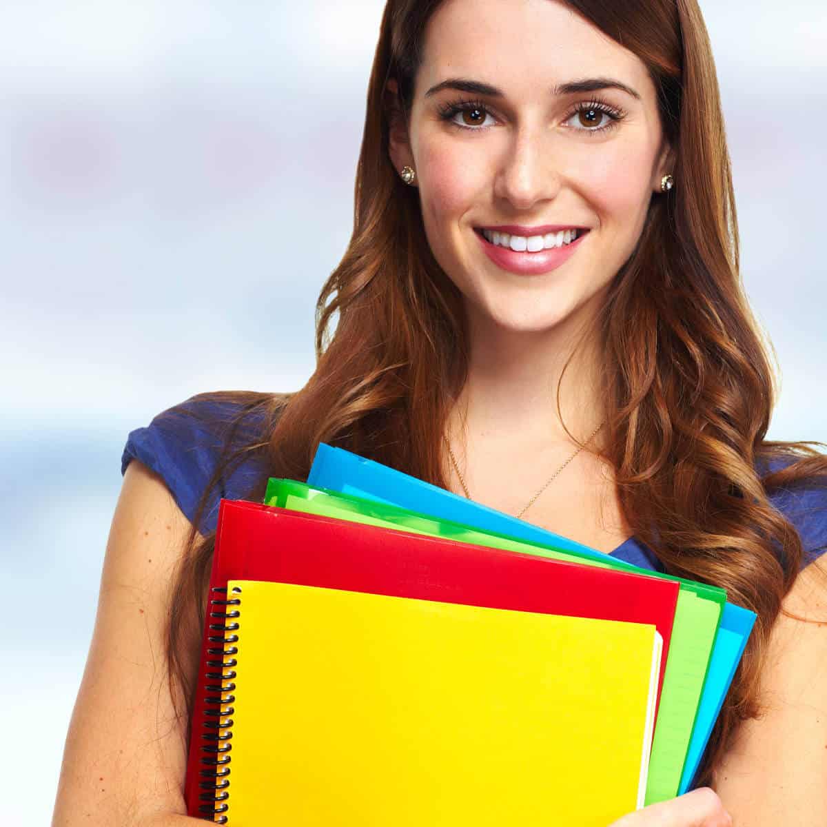 Teenage girl holding school folders.