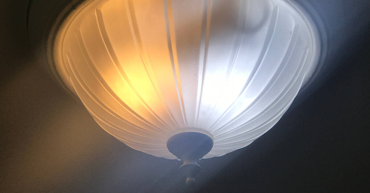 Ceiling light fixture with two different color bulbs.