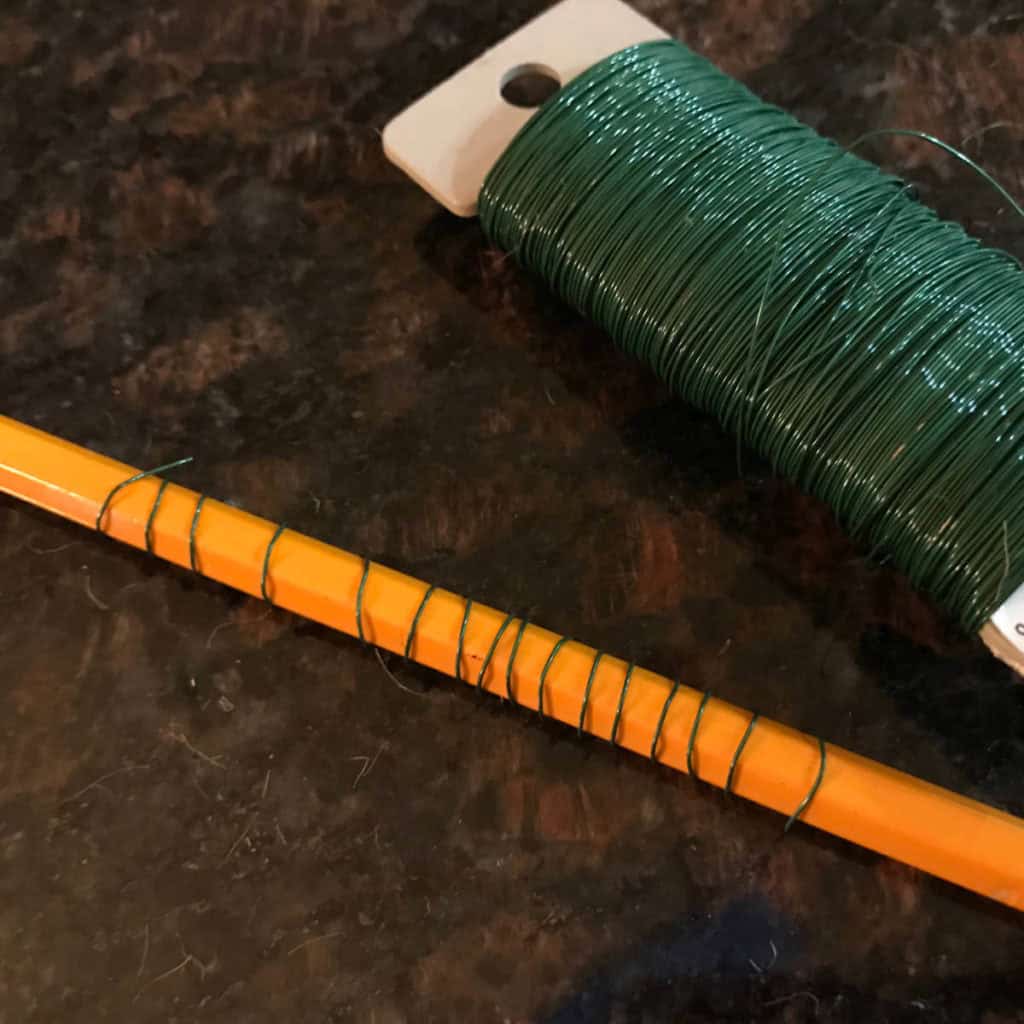 Green wire wrapped around a pencil.