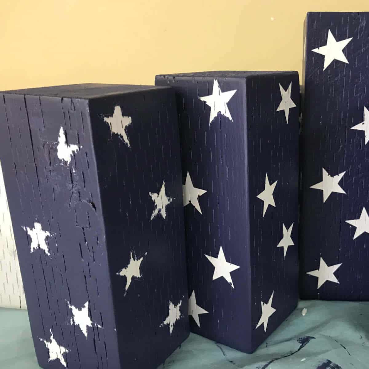 Stars painted on fence post blocks to make wood firecrackers as decor.