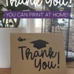 Image of a thank you card with a graduation cap sitting on a table with a plant nearby.