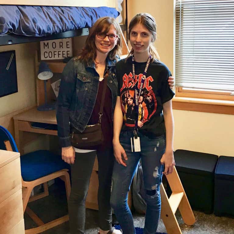 Image of a college student with her mom standing in her dorm room.