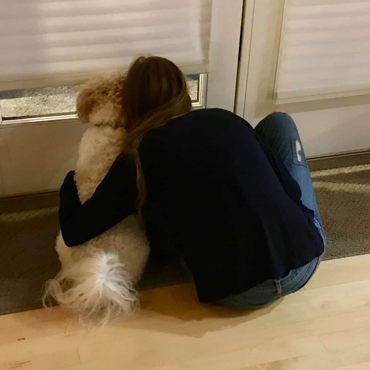 A college student hugging her dog goodbye as she leaves for college.