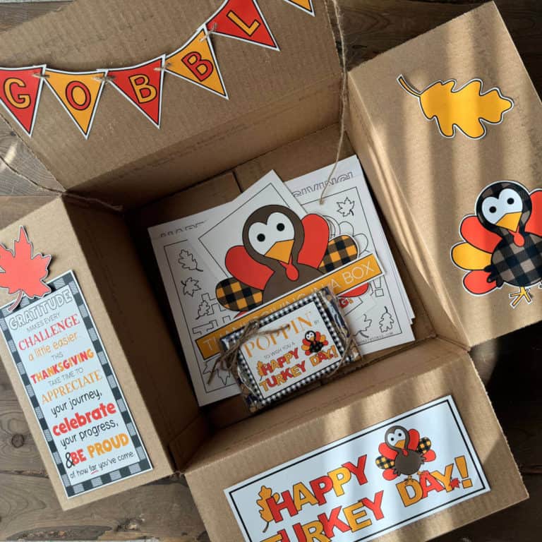 Thanksgiving care package box with printable decor on the box flaps and activity sheets in the bottom of the box.