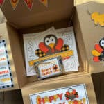 Thanksgiving Care Package Box with decor on the box flaps and printables at the bottom of the box.