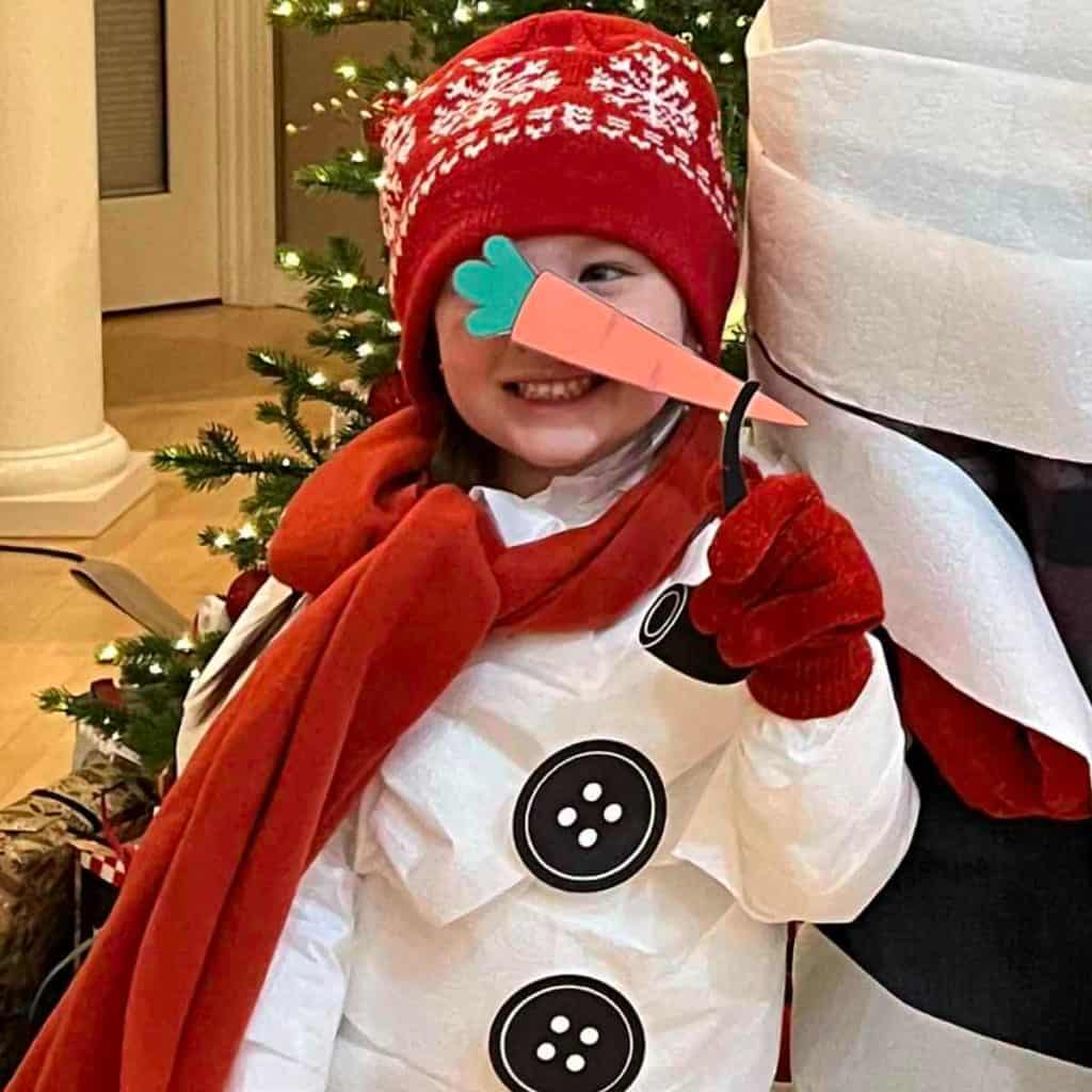 Girl dressed like a snowman using toilet paper and supplies provided as a Christmas game!