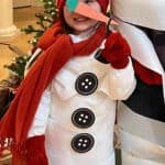 Girl dressed up like a snowman using toilet paper and printable buttons, carrot, and pipe.
