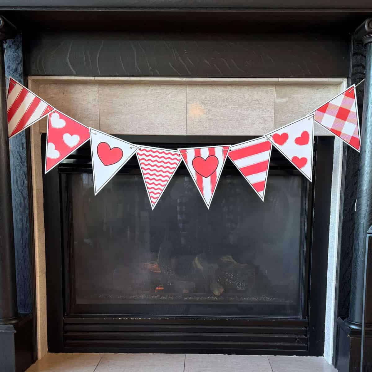 Printable Valentine banner hanging from a fireplace mantel.