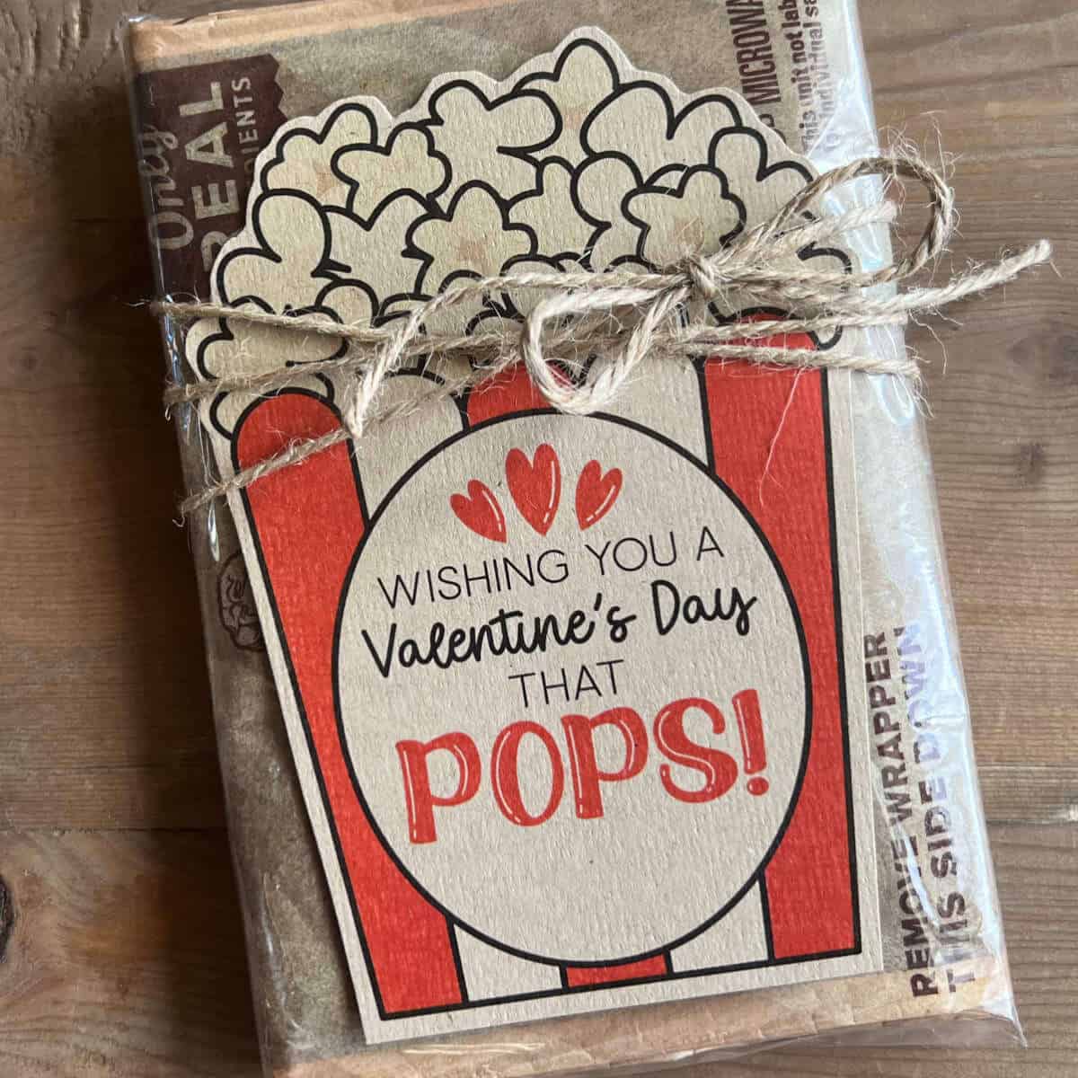 Wishing You A Valentine's Day That Pops microwave popcorn tag tied to a bag of microwave popcorn with jute.