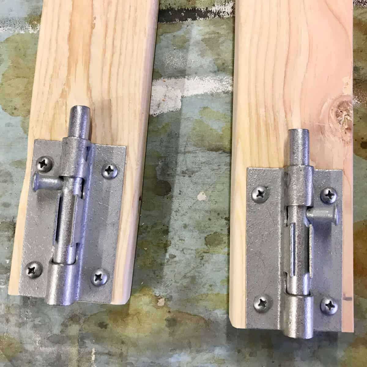 Barrel bolts on the ends of 2 x 4s.
