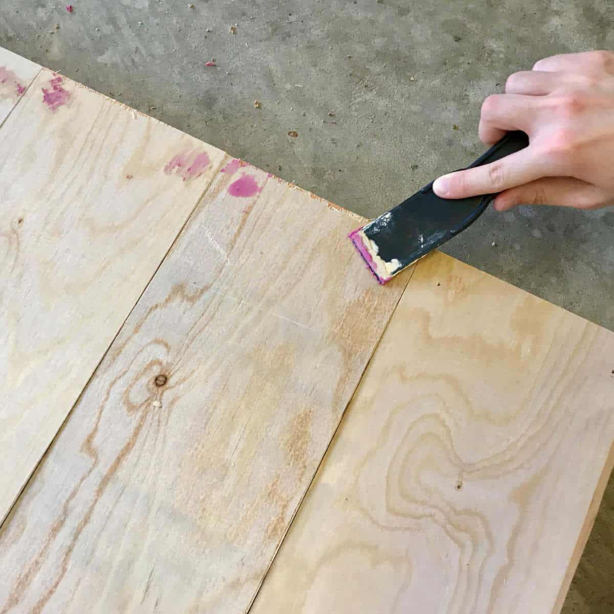 Filling nail holes with wood putty.