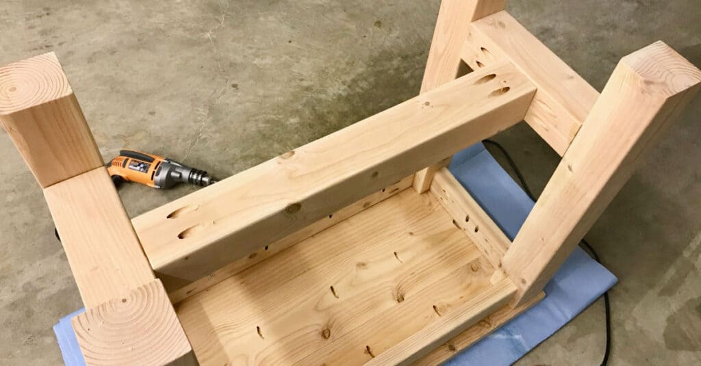 Attaching the 4 x 4 crossbar to the table base.