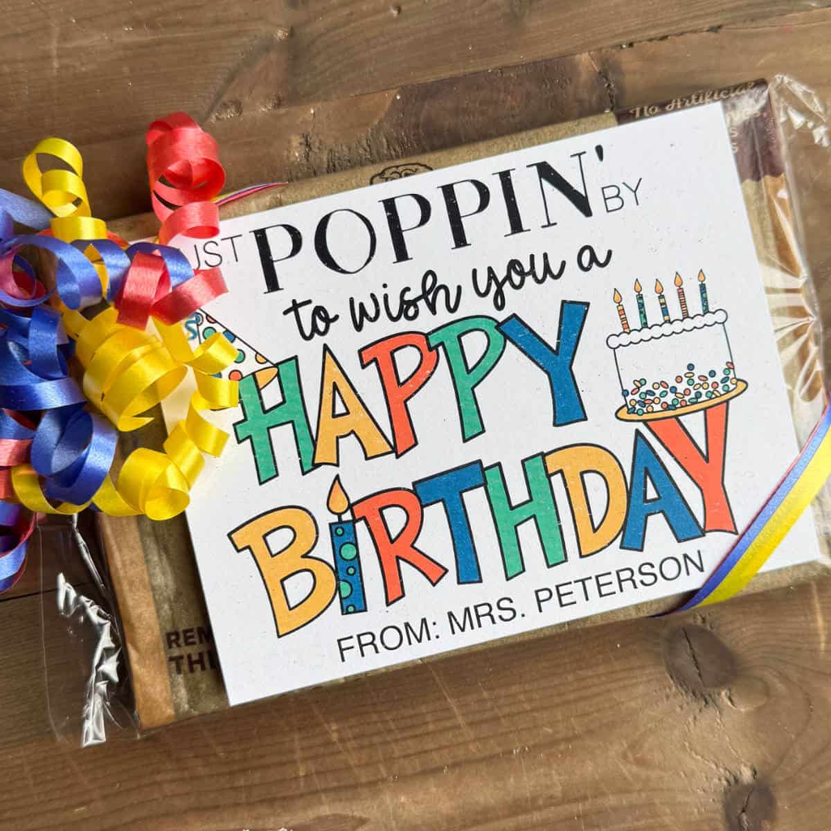 Image of a printed Happy Birthday tag tied on a bag of microwave popcorn with curling ribbon.