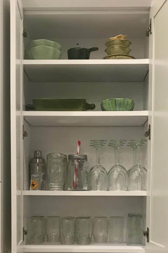 Glasses organized in a kitchen cupboard.
