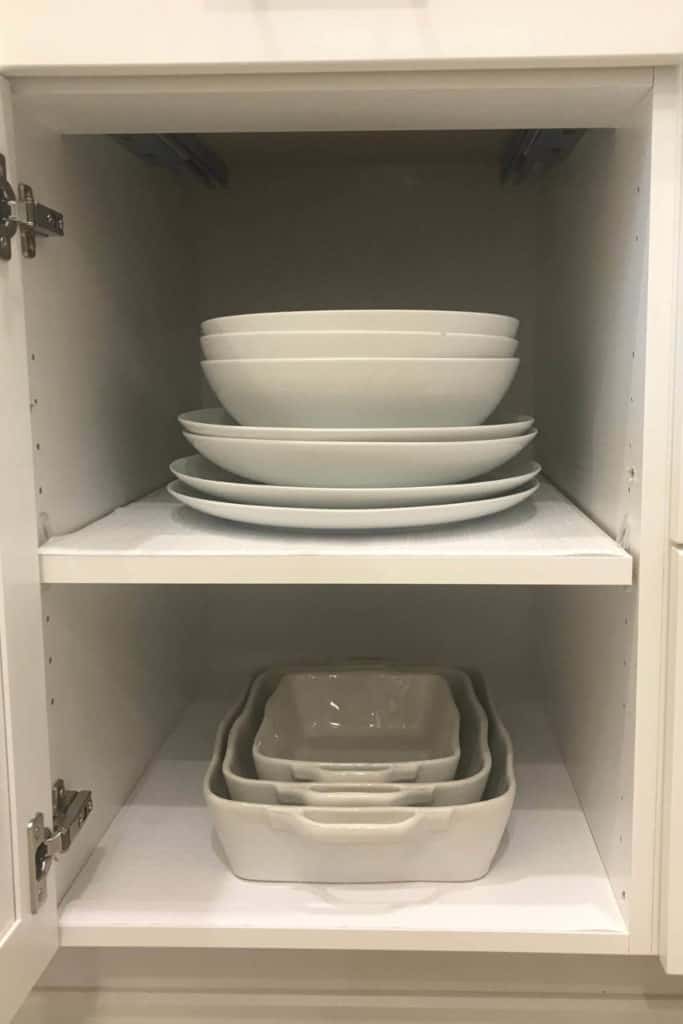 Baking dishes and serving bowls organized in a cupboard.