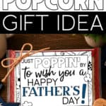 Image of a Just Poppin' By To Wish You A Happy Father's Day tag tied to a bag of microwave popcorn with Father's Day decor nearby.