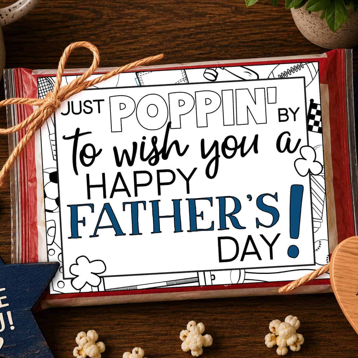 Image of a tag that says Just Poppin' By To Wish You A Happy Father's Day tied to a bag of microwave popcorn with popped popcorn nearby.