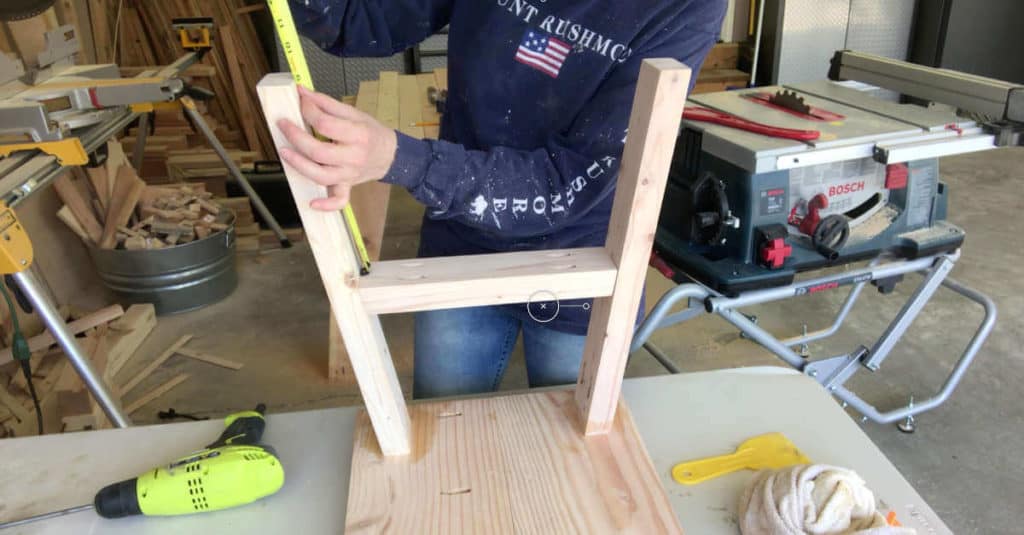 Attaching the bench leg brace by measuring and using pocket hole screws.