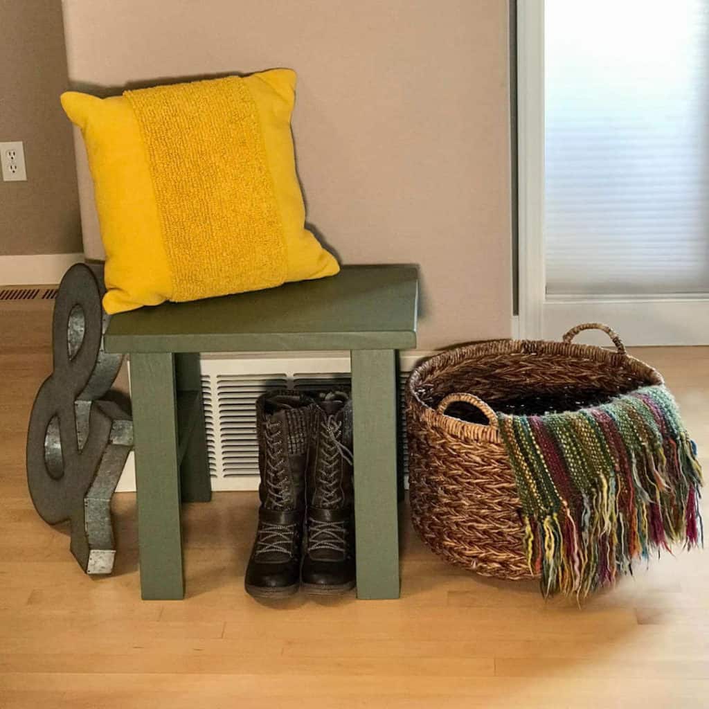 Small DIY Bench styled with a pillow, basket, boots, and artwork!