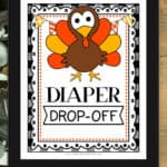 Framed sign that says Diaper Drop-Off with eucalyptus leaves around it.