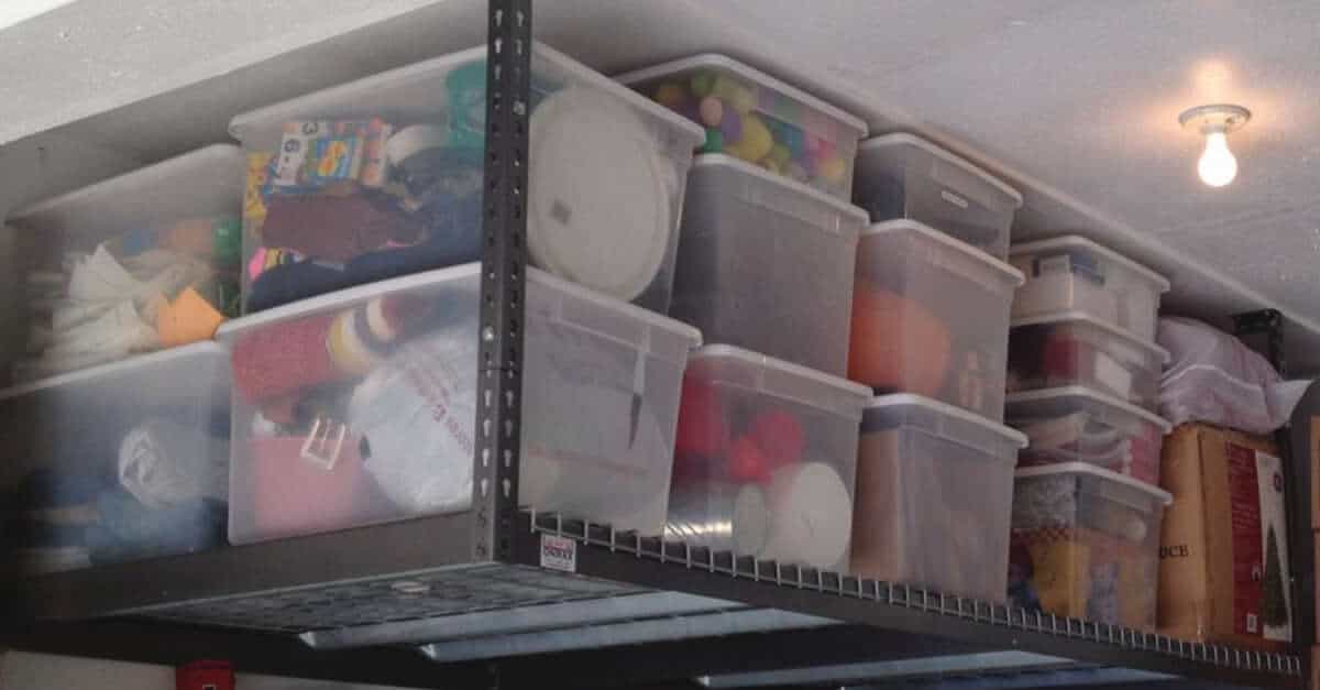 Overhead garage storage system with storage bins on it.