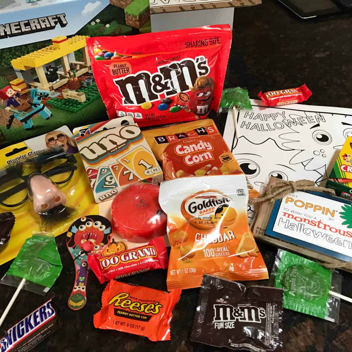 Treats and activities spread out on a counter to put in a Halloween Care Package.