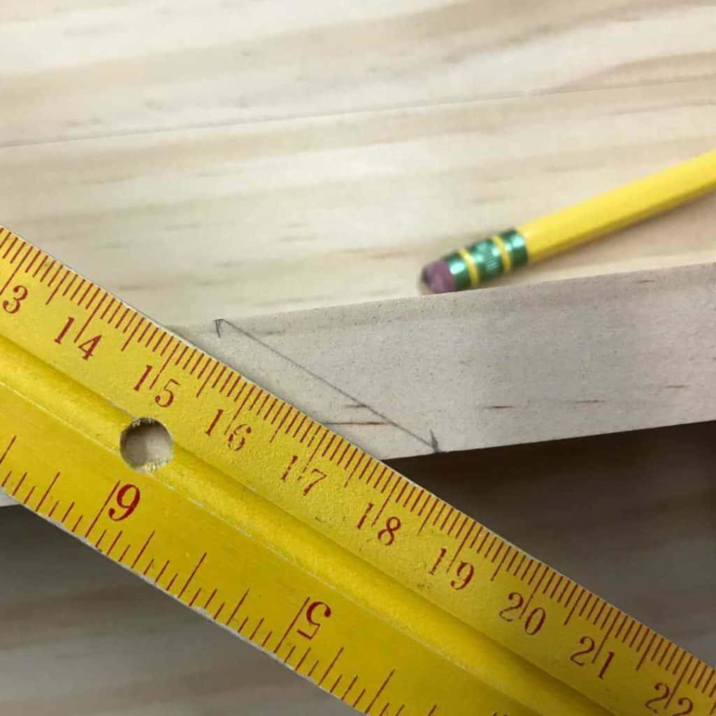Ruler and pencil used to connect two measured marks on the edge of a 1 x 3.
