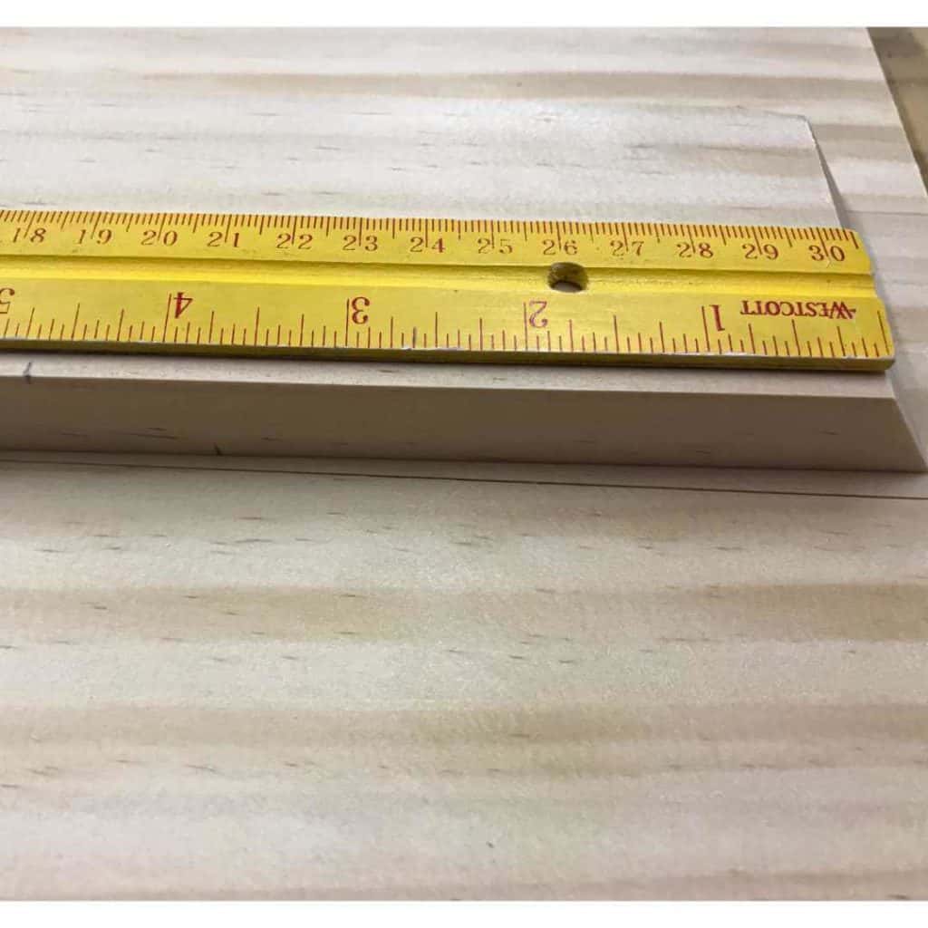 Using a ruler to measure 4-3/4" from the short angle on one edge of a 1 x 3.