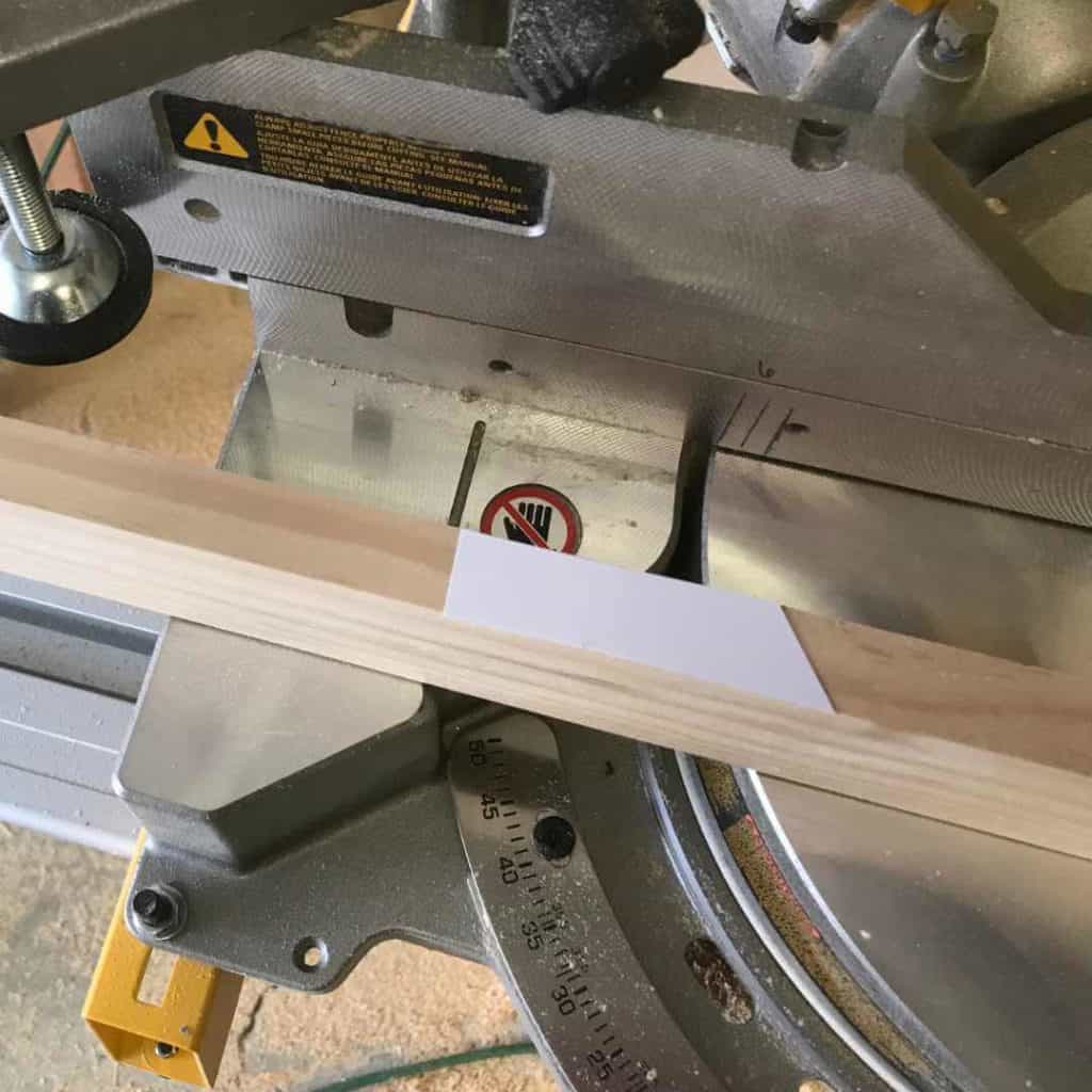 Using a paper template lined up on a cut mark to set the saw blade.