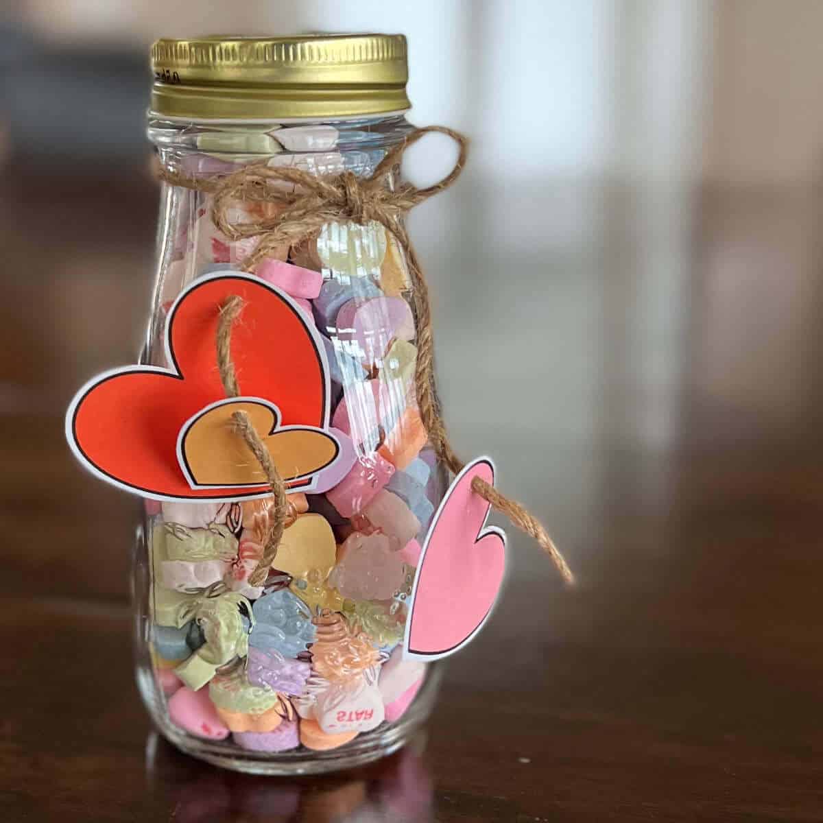 Jar full of Conversation Hearts with clip art hearts hanging from the jar.