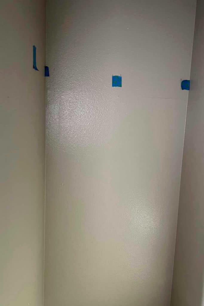 Small closet with blue tape marking where the studs are.