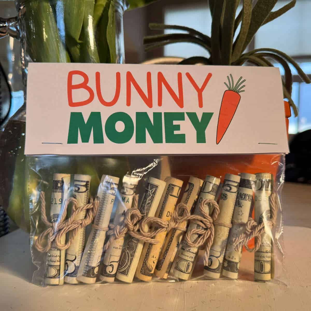 A snack size baggie full of rolled bills with a printable topper attached that says Bunny Money.