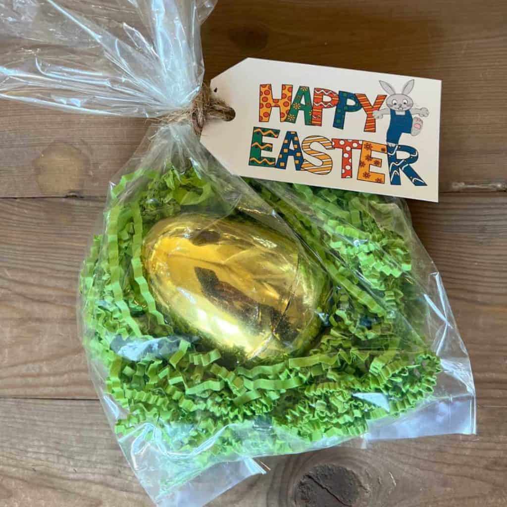 Golden Easter egg full of money, wrapped up in a clear treat bag.