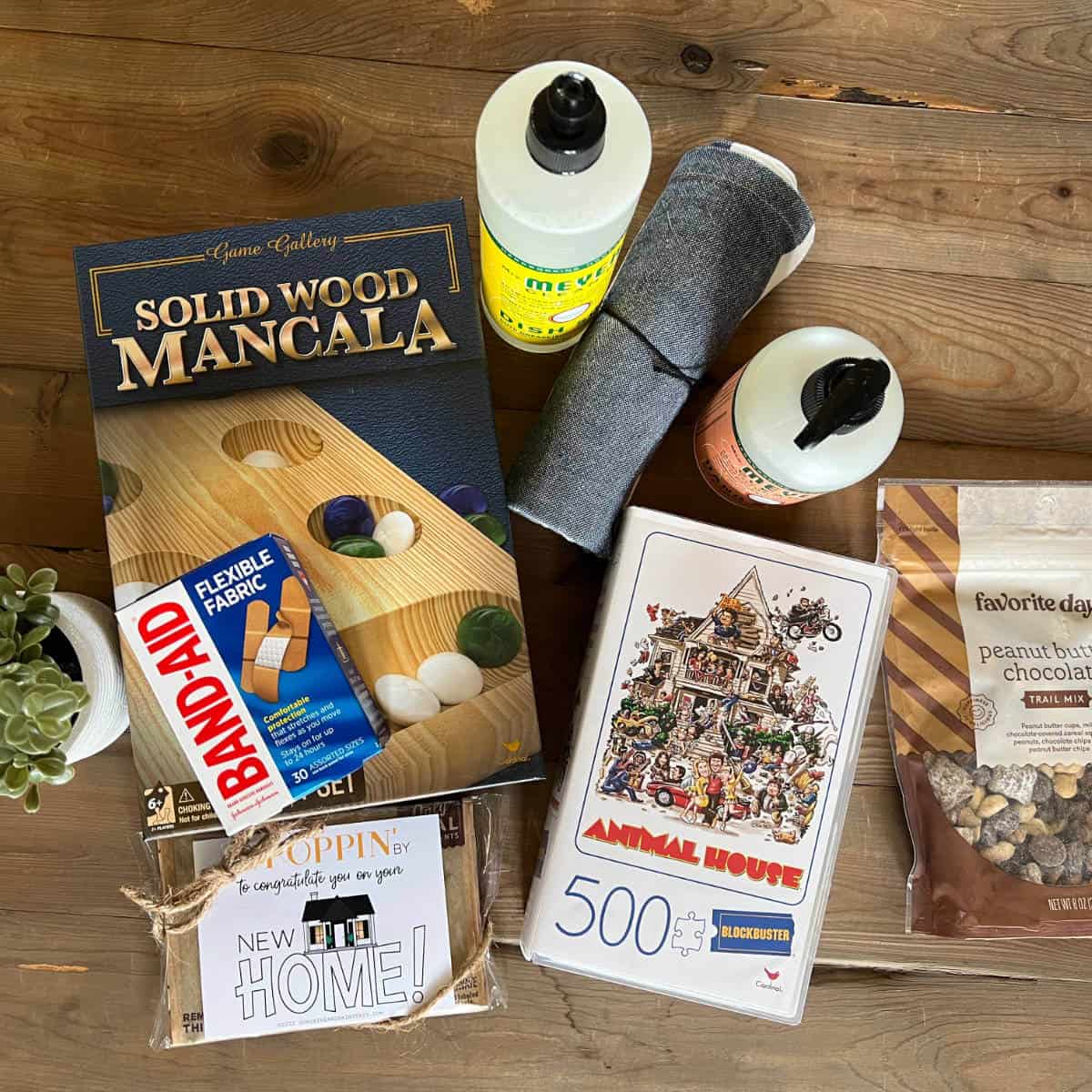 Image of a variety of things for the new home like hand soap, dish soap, hand towel, a game, band-aids, a puzzle, and a snack.