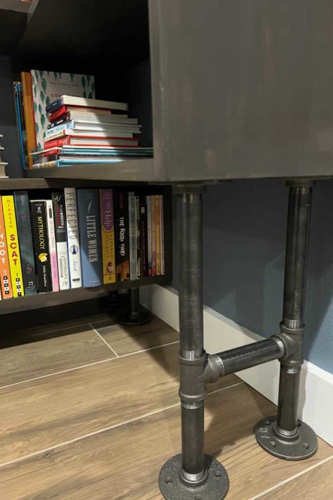 Iron pipe legs on a corner bookcase.