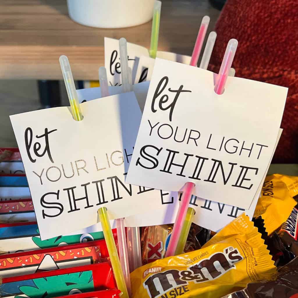 Let Your Light Shine tags on glow sticks inside a Halloween treat basket.