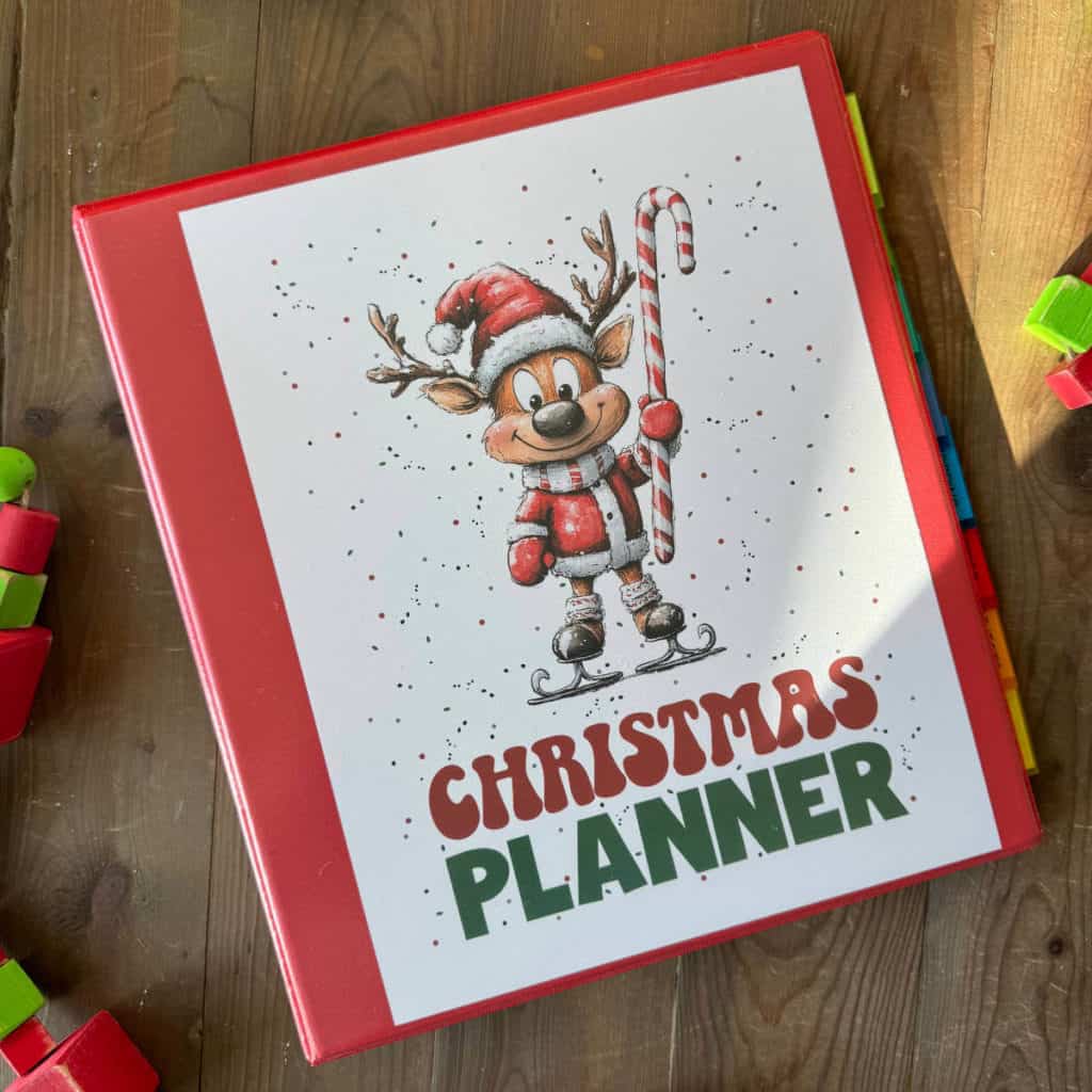 Red three-ring binder with a cover insert that says Christmas Planner with a picture of a cute reindeer.