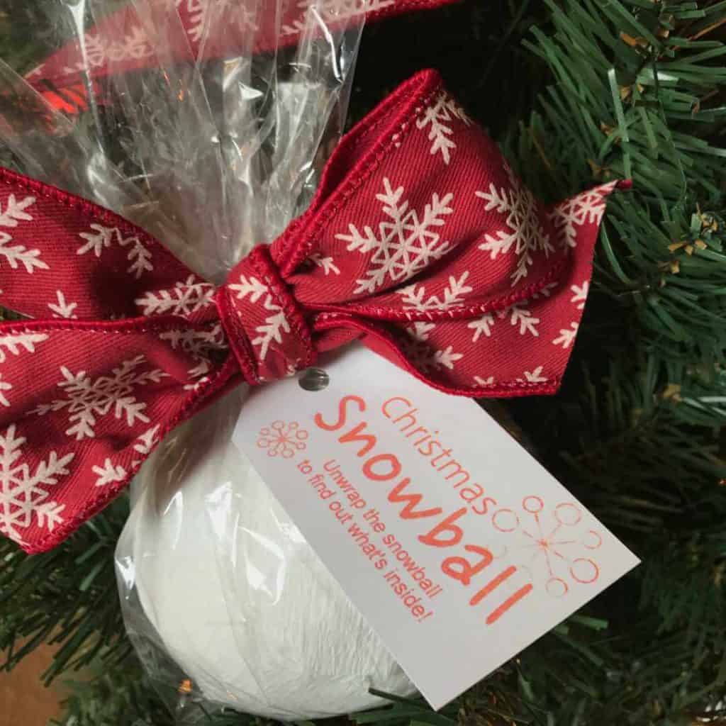 Christmas Snowball wrapped with white streamer, placed in a clear bag, and tied with a festive ribbon.
