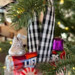 Train ornament made out of candy and hanging on a Christmas tree.