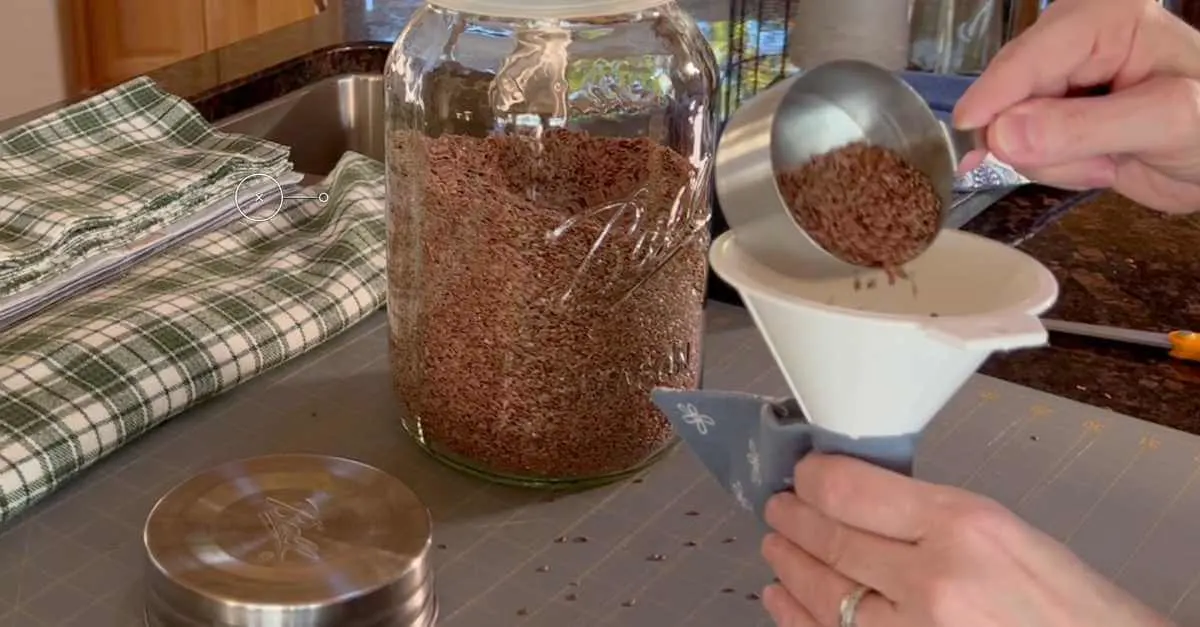 Filling a heating bag with flax seeds, using a 1/2 cup and funnel.
