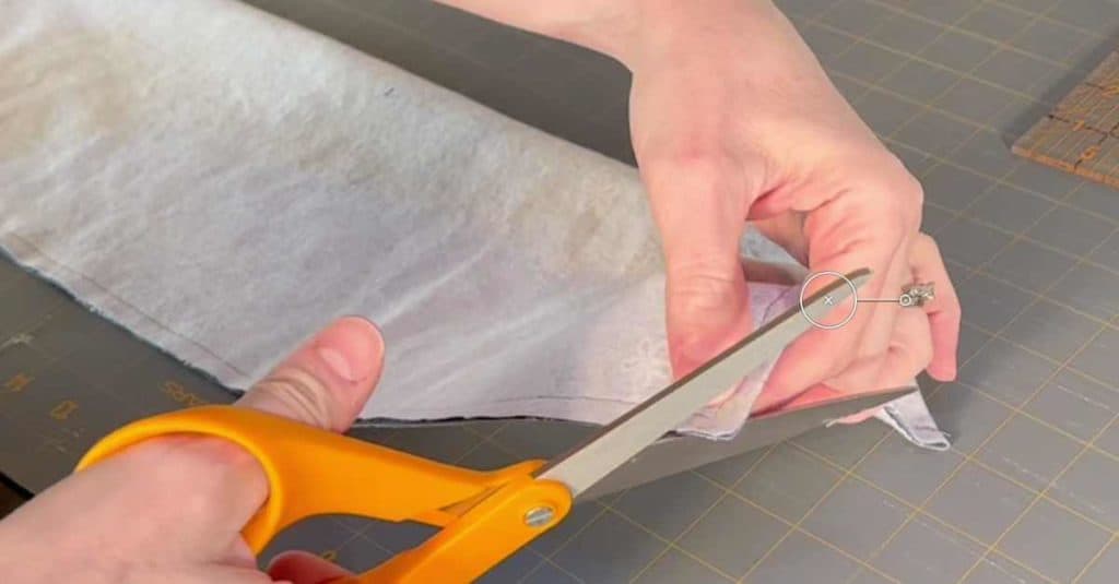 Cutting the corners of a flax seed heating bag to reduce bulk.