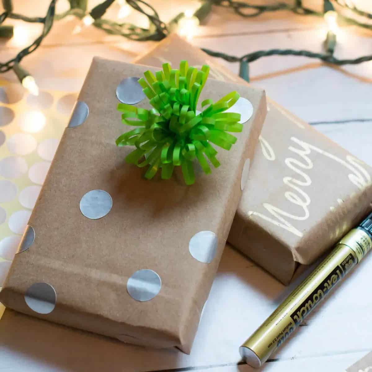 Gifts wrapped with bags and decorated with a paint pen and bow.