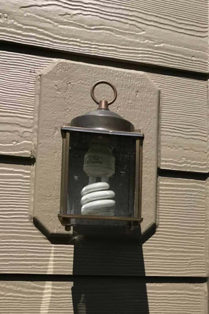 Old light fixture with coil fluorescent bulb.