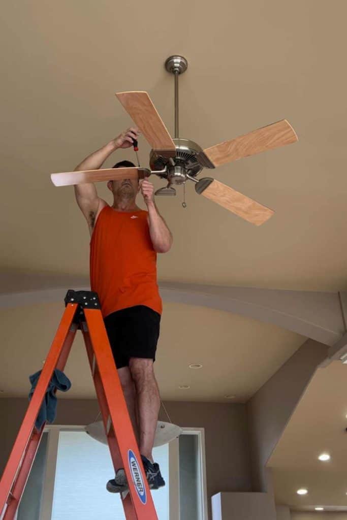 Steve taking ceiling fan blades off so we can paint them.